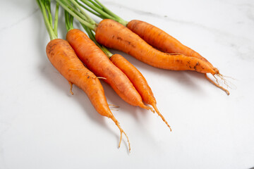 Close up of ripe carrots on light surface