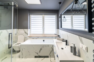 Fototapeta na wymiar Modern flat bathroom with grey walls and white bath