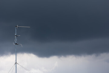 Television antenna on the roof of the building against the dark blue sky. Photo taken in the...