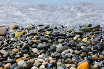 Colored wet pebbles on the sea, pebble beach