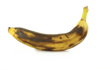 Single overripe black banana isolated on white background. Decomposing tropical fruit