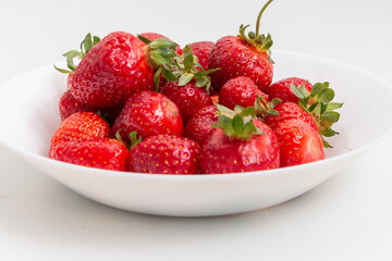Fresh ripe strawberries in a white plate. Dessert. Close-up. Harvest strawberries.