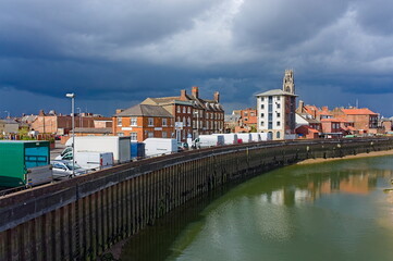 Boston by the river Witham with row of parked white vans