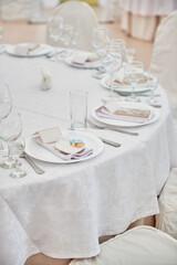 Table setting with plate, white napkin and cutlery on table, copy space. Place set at wedding reception. Table served for wedding banquet in restaurant