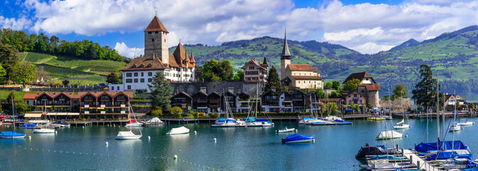 Scenic lake Thun and the Spiez village with its famous medieval castle and old town in the alps in...