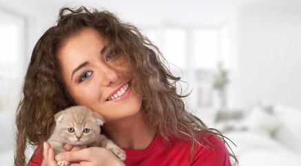 Portrait of young woman holding cute cat. Adorable domestic pet concept.