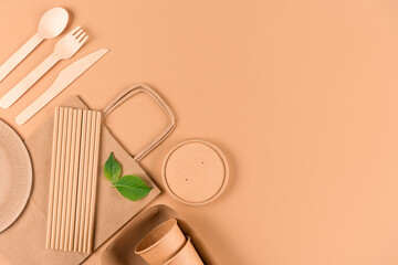 Eco-friendly tableware - kraft paper food packaging over light brown background with copy space....