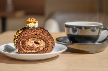 chocolate cake with ground nuts on top. Sweet swiss chocolate roll and coffee in cafe.