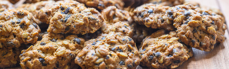 panoramic view of golden crispy oatmeal cookies. Baking background