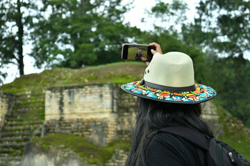 Mujer latina tomando un autorretraro en la Ruinas de Iximche en Guatemala.