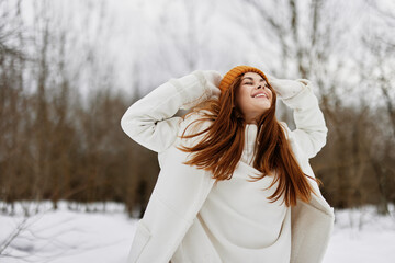 Happy young woman in winter clothes in a hat fun winter landscape fresh air