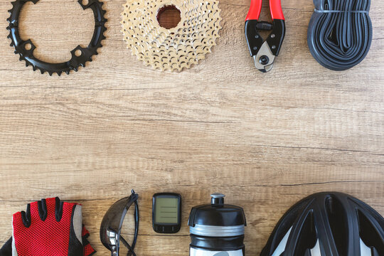 Bicycle accessories and parts in a row on a brown wooden background. Workshop and sporty lifestyle concept copy space