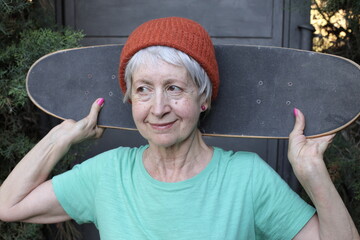 Cool looking senior woman holding a skateboard © ajr_images