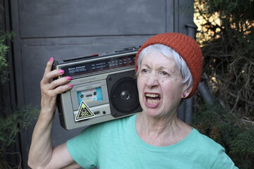 Senior woman carrying stereo cassette player