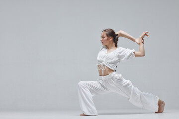 Beautiful young modern dancer or fitness dancer on a white isolated background