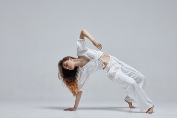 Beautiful young modern dancer or fitness dancer on a white isolated background