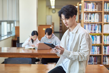 아시아 한국의 대학교 도서관에서 2명의 남녀 모델 배경으로 책상위에...