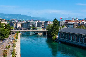 Fototapeta na wymiar Geneva, Switzerland - June 3, 2022: Cityscape of Geneva with a river Rhone and a bridge 