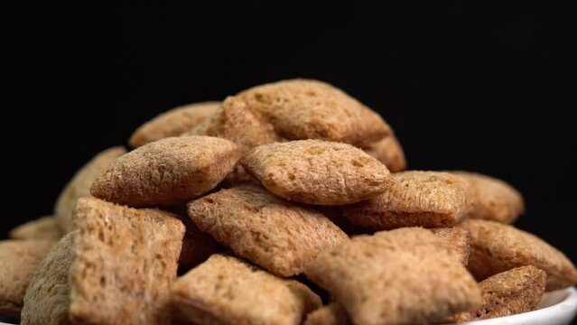 Crispy chocolate pads rotate on a black background.