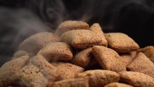 Hot crispy chocolate pads with smoke rotate on a black