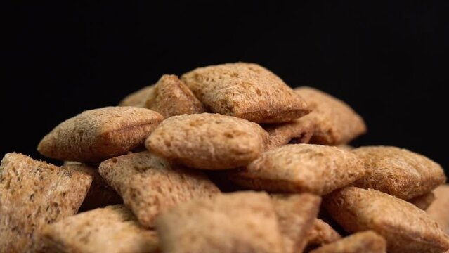 Crispy chocolate pads rotate on a black background.