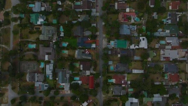 Top down footage of family houses in residential neighbourhoods. Low buildings with gardens and swimming pools. Port Elisabeth, South Africa