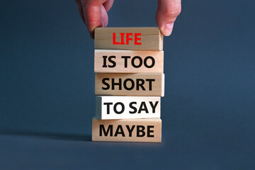 Life is short for maybe symbol. Concept words Life is too short to say maybe on wooden blocks on a beautiful grey table grey background. Businessman hand. Business motivational life or maybe concept.
