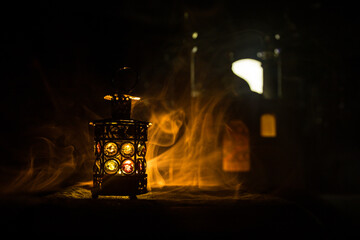 Ornamental Arabic lantern with burning candle glowing at night. Festive greeting card, invitation for Muslim holy month Ramadan Kareem.