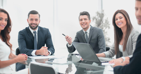 group of business people sitting at a table in the office