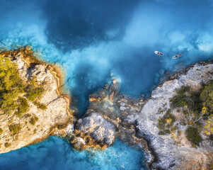Luftbild von Menschen auf schwimmenden Kajaks auf blauem Meer, felsiger Küste, Bäumen bei Sonnenuntergang im Sommer. Blaue Lagune, Ölüdeniz, Türkei. Tropische Landschaft. SUP-Boards auf klarem Wasser. Draufsicht auf Kanu. Tourismus © den-belitsky