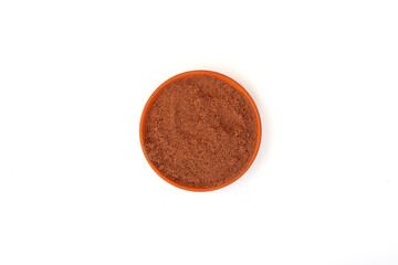 Bird cherry flour in clay plate on white background, top view. Shredded berry Bird cherry use in baking and healthy smoothie