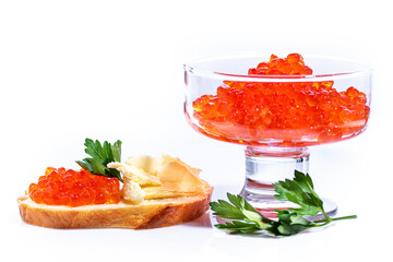 Red caviar on roll of butter decorated with green parsley on top. Caviar in transparent cup on white background.