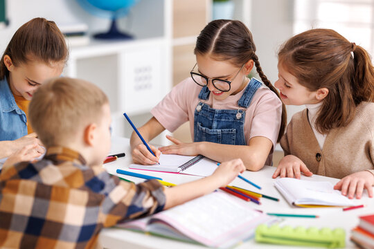 Diligent schoolkids solving test with classmates