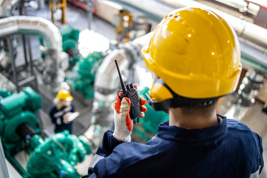 Refinery worker or supervisor with radio control checking oil and gas production or pipeline.
