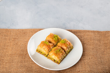 Pistachio baklava on a white plate.A plate baklava on bright background