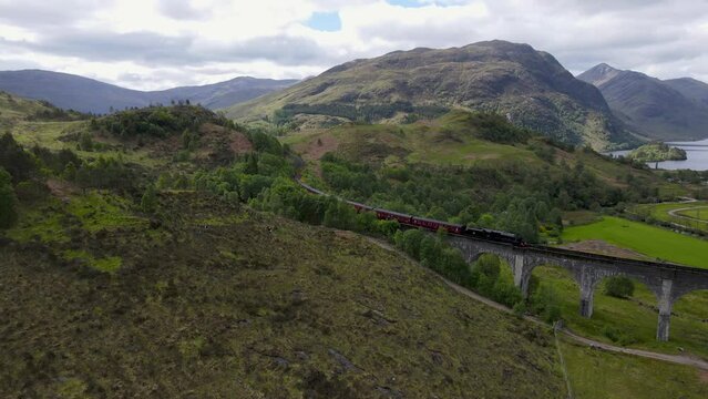 Steam Train on Glenfinnan Viaduct with Loch Shiel in the Background in the Scottish Highlands, UK