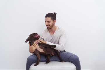 Man on a white background smiling with his dog