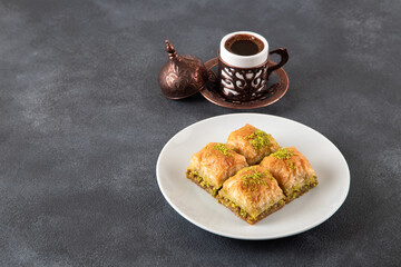 Pistachio baklava on a white plate with Turkish coffee