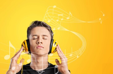 Sincere handsome man smiles wears headphones on ears listens favorite music