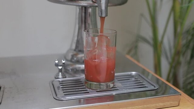 chica coloca vaso de cristal para servirse jugo fresco, toma cerrada.