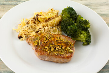 Pork chop with crushed pistachios and orange marmalade, broccoli and potato wedges with cheese