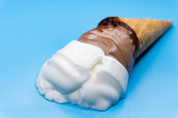 angle view melting flower shape cocoa flavor ice cream cone on a blue background
