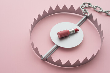 Red lipstick in a trap on pink background copy space. Online internet romance scam or swindler in...