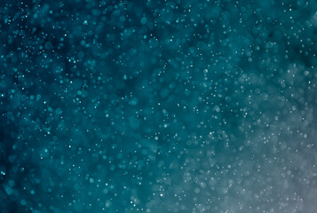 Abstract blurred glitter on blue light effects background.