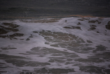 Ocean waves rolling in towards the wet sandy shore at Ocean beach