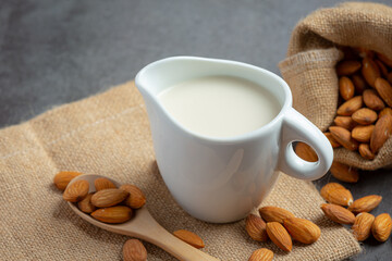Almond milk with almond on dark background