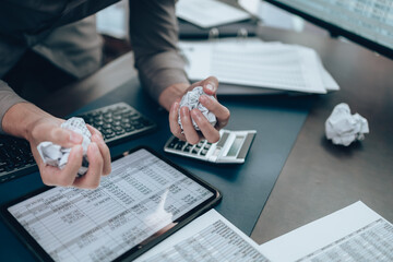 Serious Investors have a mad crump paper and angry while working  on the desk.  Accounting and ...