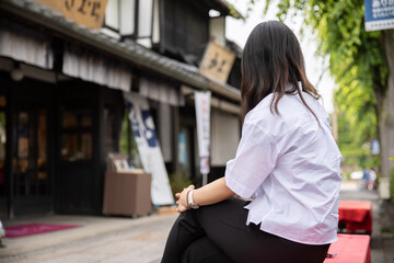 Fototapeta premium 風情ある町並みに腰掛ける女性 Taste
