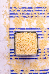 Dry risoni pasta in a glass jar