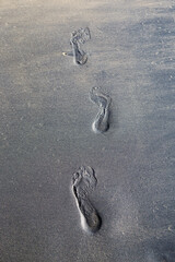 Foot print on Black sand beach background, Khao Lak, south of Thailand, Nang Thong beach, vertical style